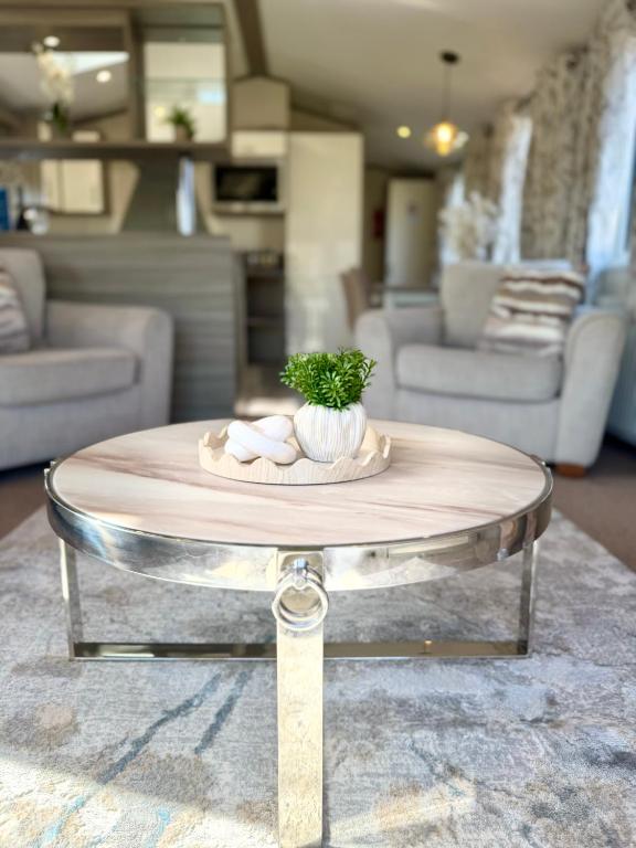 a round table with a plant on top of it at Archerfield Luxe Lodge in Port Seton