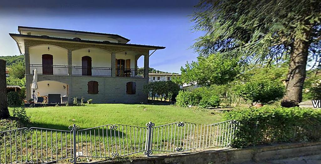 an old house in a yard with a fence at Ca' di Romagna B&B in Civitella di Romagna