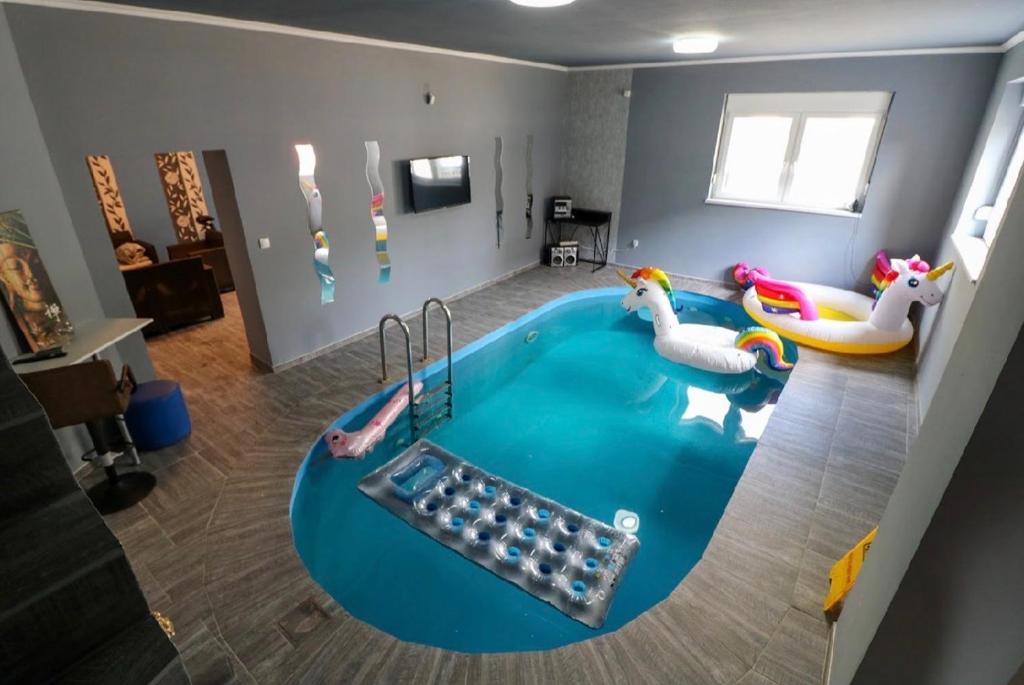 a living room with a pool with inflatable animals at KK Vip Apartment in Palić