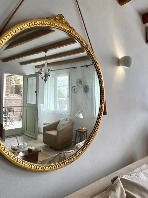 a mirror in a living room with a chair and a couch at Aegean Breeze in DYO CHORIA TINOS in Triandáros