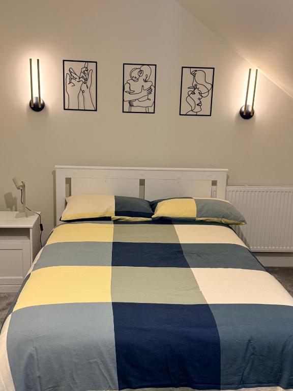 a bedroom with a bed with blue and yellow stripes at Birch view getaway in Dunshaughlin