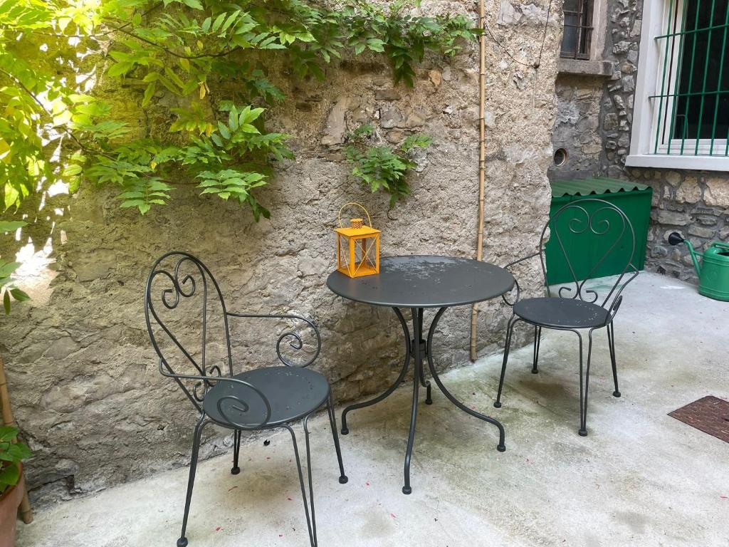 two tables and chairs with a lantern on a patio at Prima Del Cielo - Appartamento Lago in Esino Lario