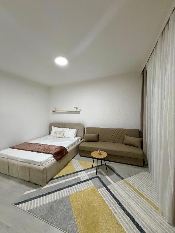 a bedroom with a bed and a couch at Spring Studio Apartment in Prizren