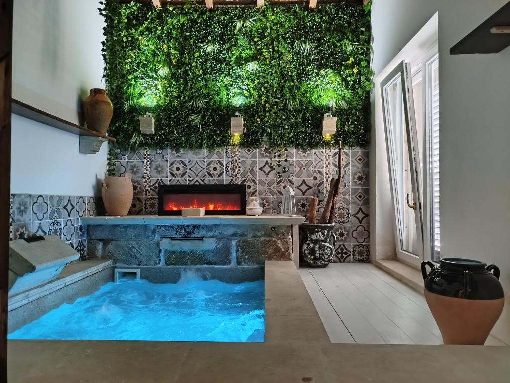 a hot tub in a room with a fireplace at Masseria Petra in Martano