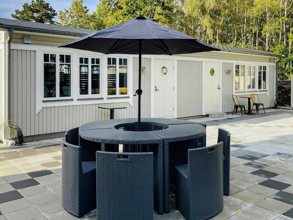 a table and chairs with an umbrella on a patio at 4 star holiday home in SÖLVESBORG in Sölvesborg