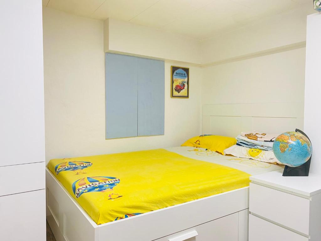 a white room with a bed with a yellow blanket at Skovhus 2-room Basement Apartment in Aarhus