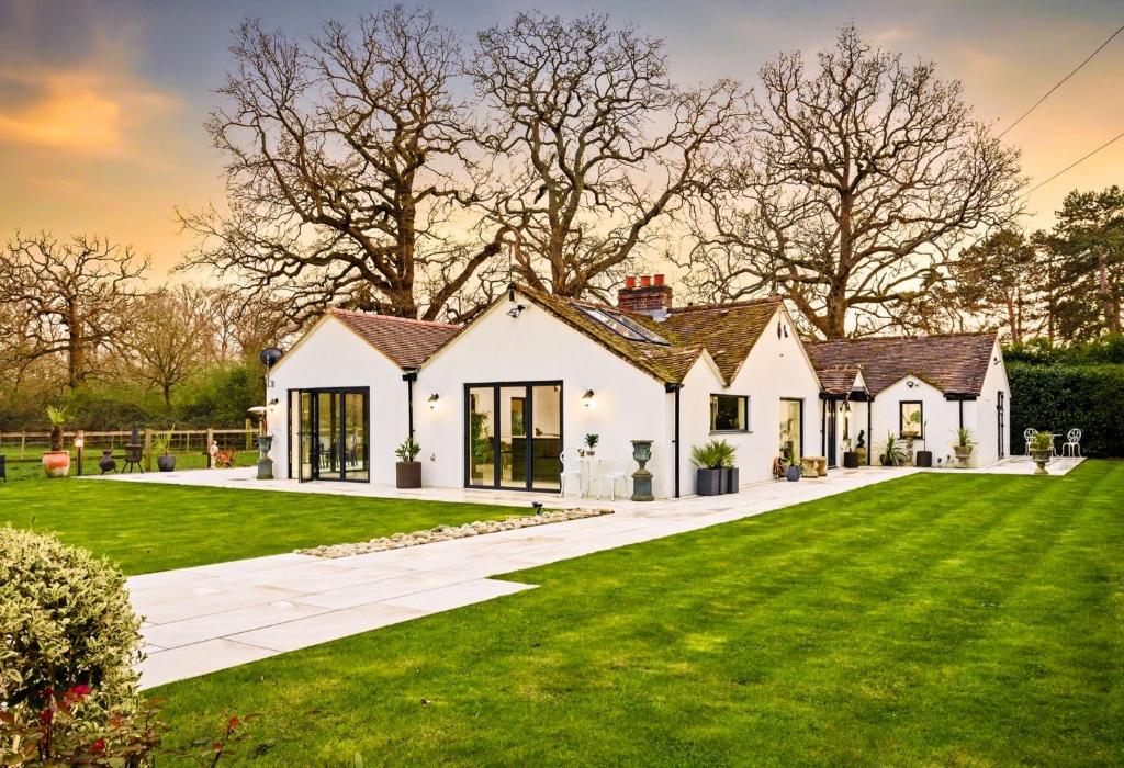 a house with a green lawn at Luxury Ascot Villa Steps from Royal Ascot, 5 mins to Legoland Windsor Resort, 10 mins to Windsor Castle in Ascot