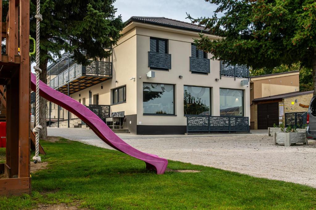 a purple slide in the grass in front of a house at San Marco - Na Brněnské ulici in Mutěnice
