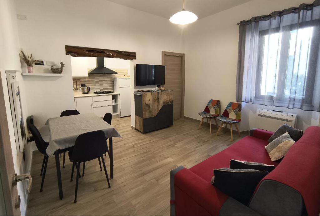 a living room with a red couch and a table at B&B Baroi Orgosolo in Orgosolo
