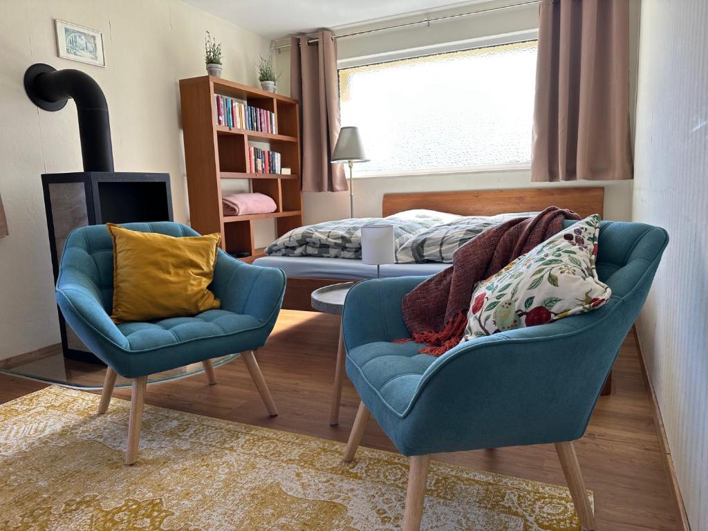 a living room with two chairs and a bed at Ruhige Gartenwohnung in Königs Wusterhausen