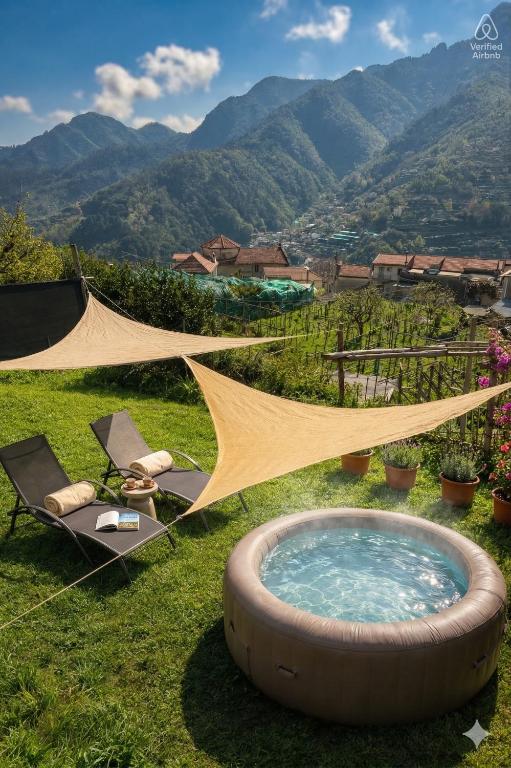 a hot tub in the grass with a tent and chairs at Villa dei Filari in Tramonti