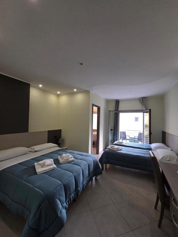 a bedroom with two beds and a large window at Hotel Rodian in Acquappesa