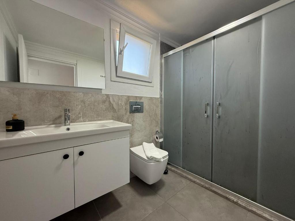 a bathroom with a white sink and a toilet at Villa Atay in Dalyan