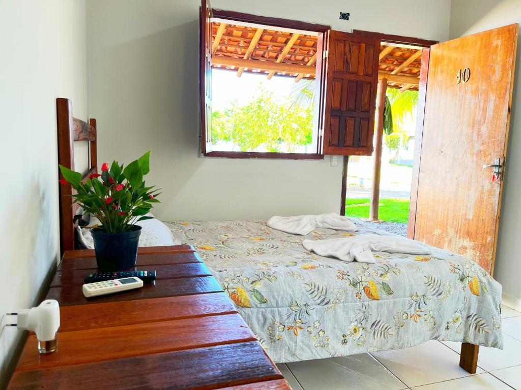 a bedroom with a bed and a window at Pousada Elizium in Montes Claros