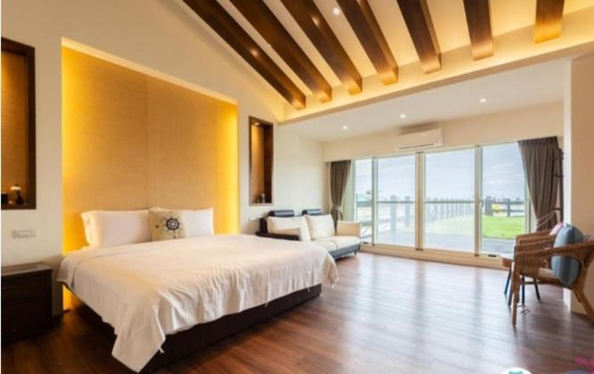 a bedroom with a large bed and a large window at After the Court Chiaohsi in Jiaoxi