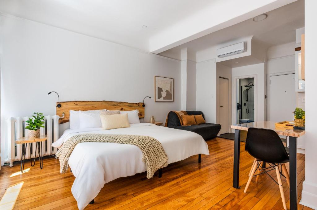 ein Schlafzimmer mit einem großen Bett und einem Schreibtisch in der Unterkunft Lofts Le Petit Champlain in Québec