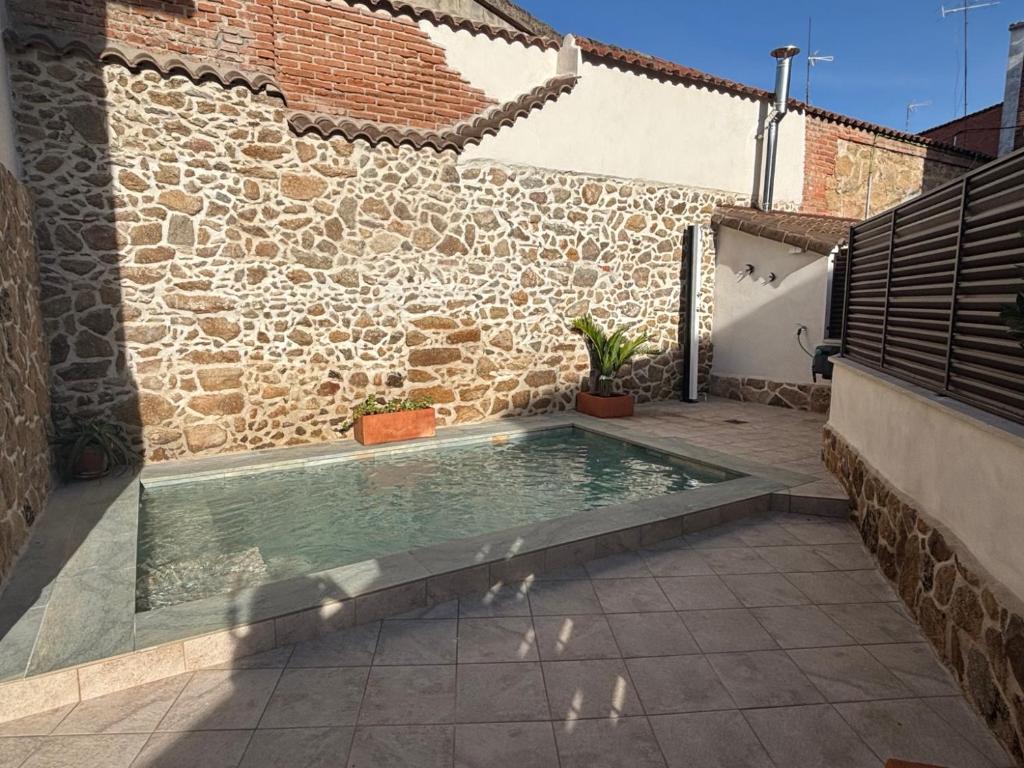 a swimming pool in the courtyard of a house at La Casina Casa rural con piscina privada y patio cerca de Gredos in Navalcán