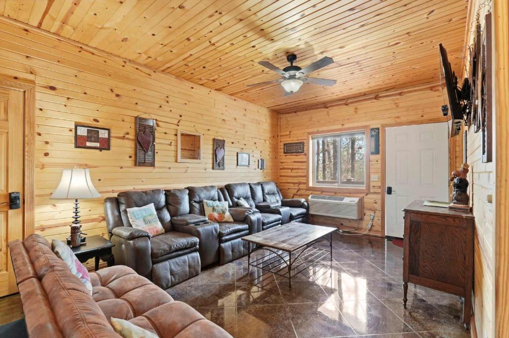 a living room with a couch and a ceiling fan at Quail Cove Oak Premium Lakefront Condo Boat Slip in Shell Knob