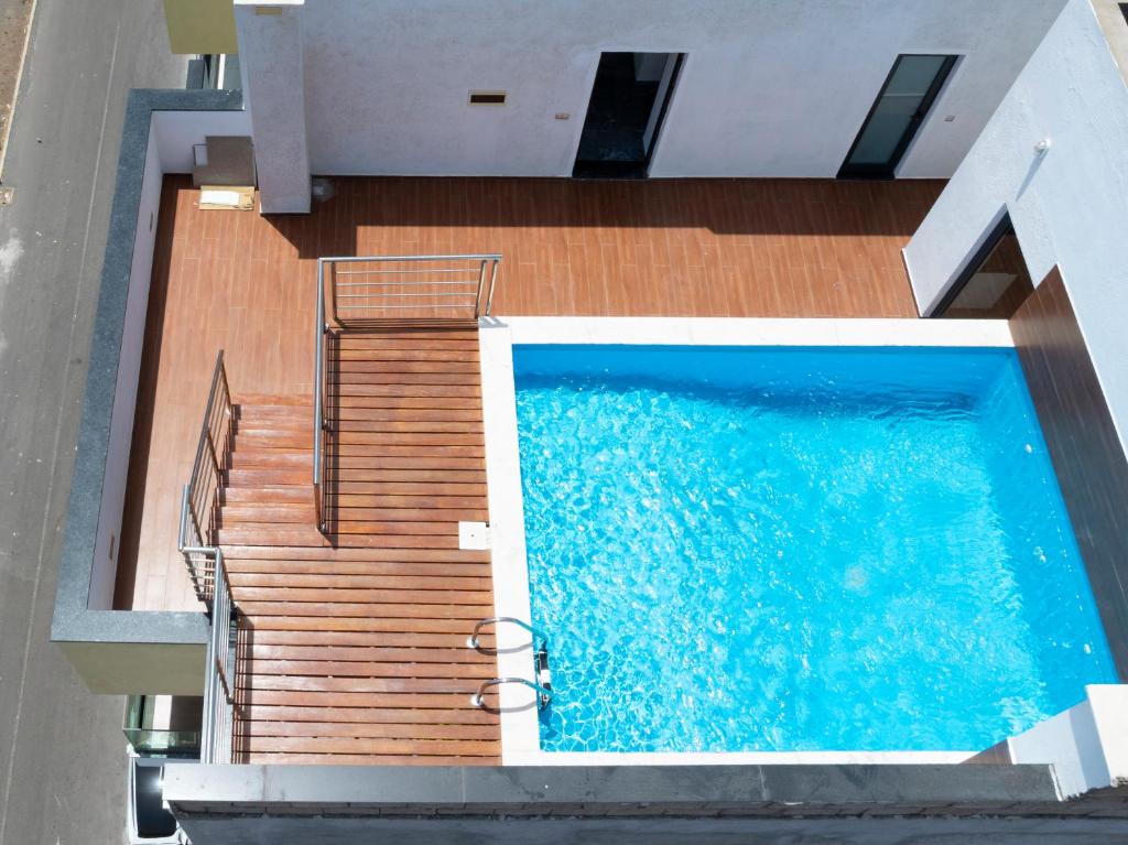 an overhead view of a swimming pool next to a wooden deck at Modern 2-bdr apt with rooftop pool - LCGR in Praia