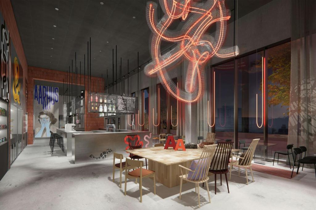 a dining room with a table and chairs and a chandelier at Moxy Aarhus in Aarhus