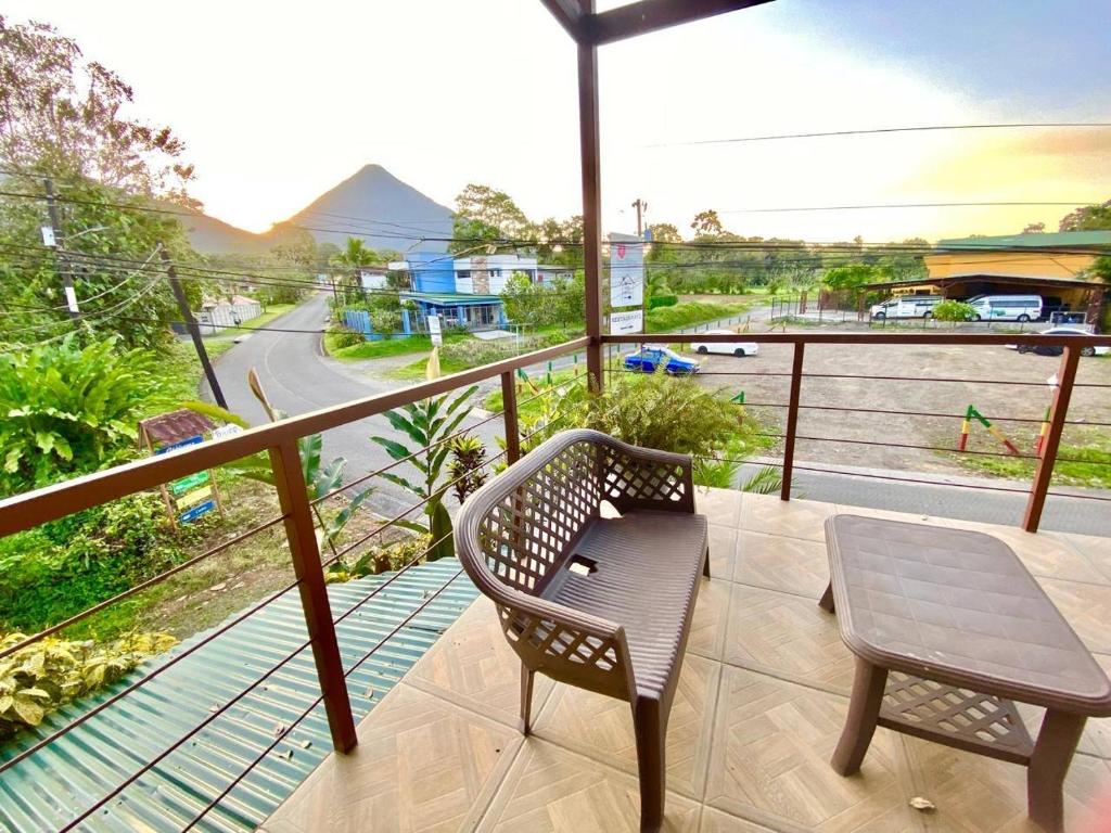 a balcony with a table and chair and a view of a street at Arenal Views, Pool & 5min to Waterfall & Town in Fortuna