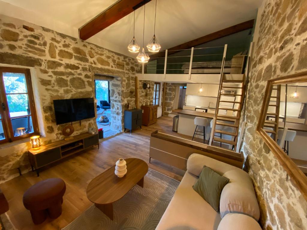 a living room with a couch and a table at Maison de charme en pierre in Porto Ota