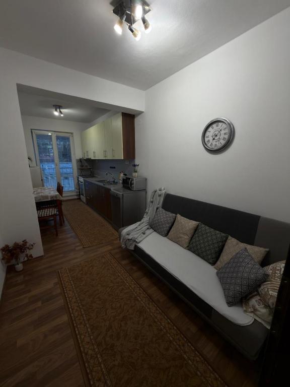 a living room with a couch and a clock on the wall at Apartmán pod Čebraťom in Ružomberok