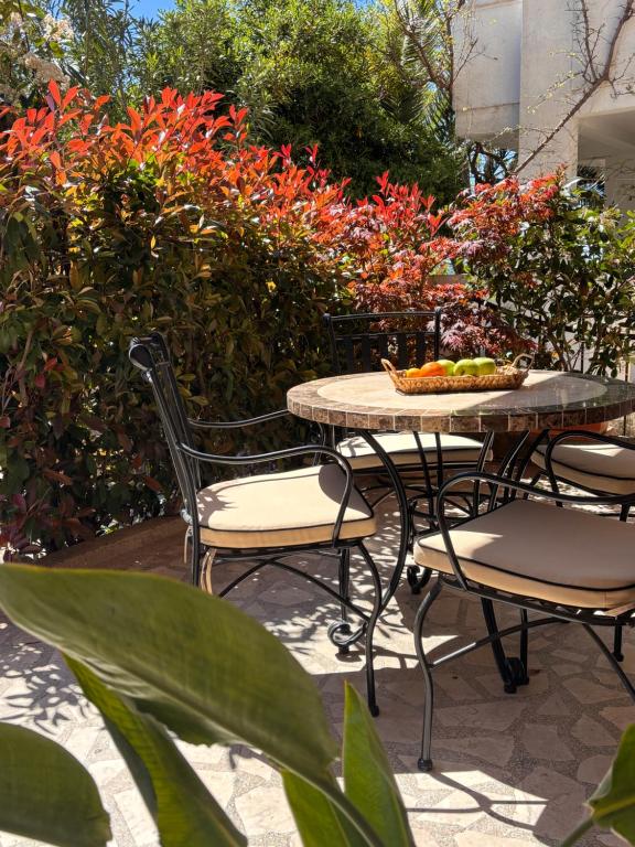 a table and chairs on a patio with flowers at Passiflora apartment - near the sea in Šušanj