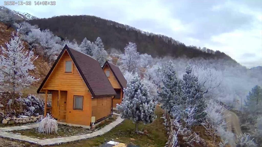 a cabin in the mountains with snow on the trees at Camp Volujak in Gacko