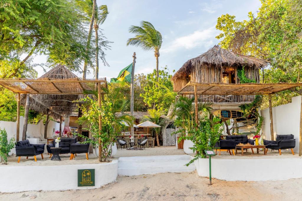 a resort on the beach with chairs and umbrellas at Treehouse Kitecamp Jericoacoara in Jericoacoara