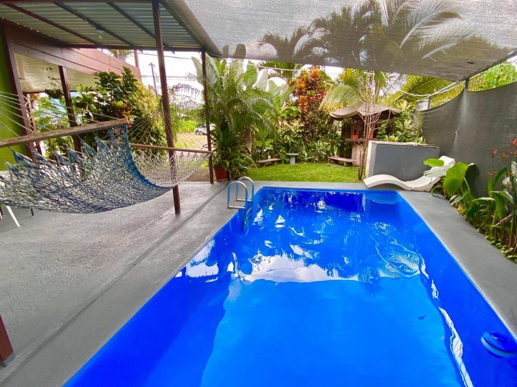 a swimming pool with blue water in a backyard at Heliconia Suite 5min to Waterfall - Shared Pool Pool in Fortuna