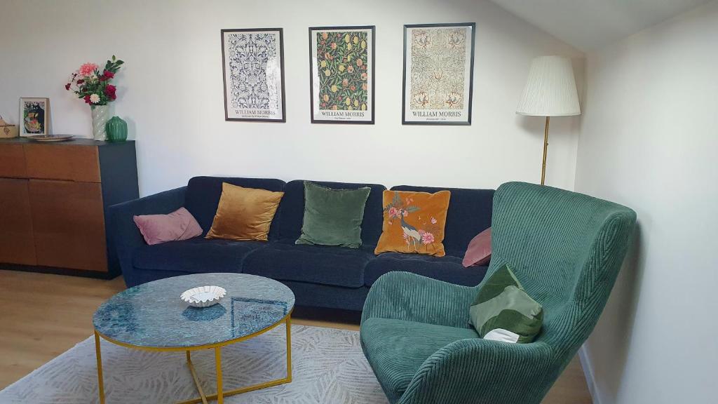 a living room with a blue couch and two chairs at Le Jardin de Madison in Cessy