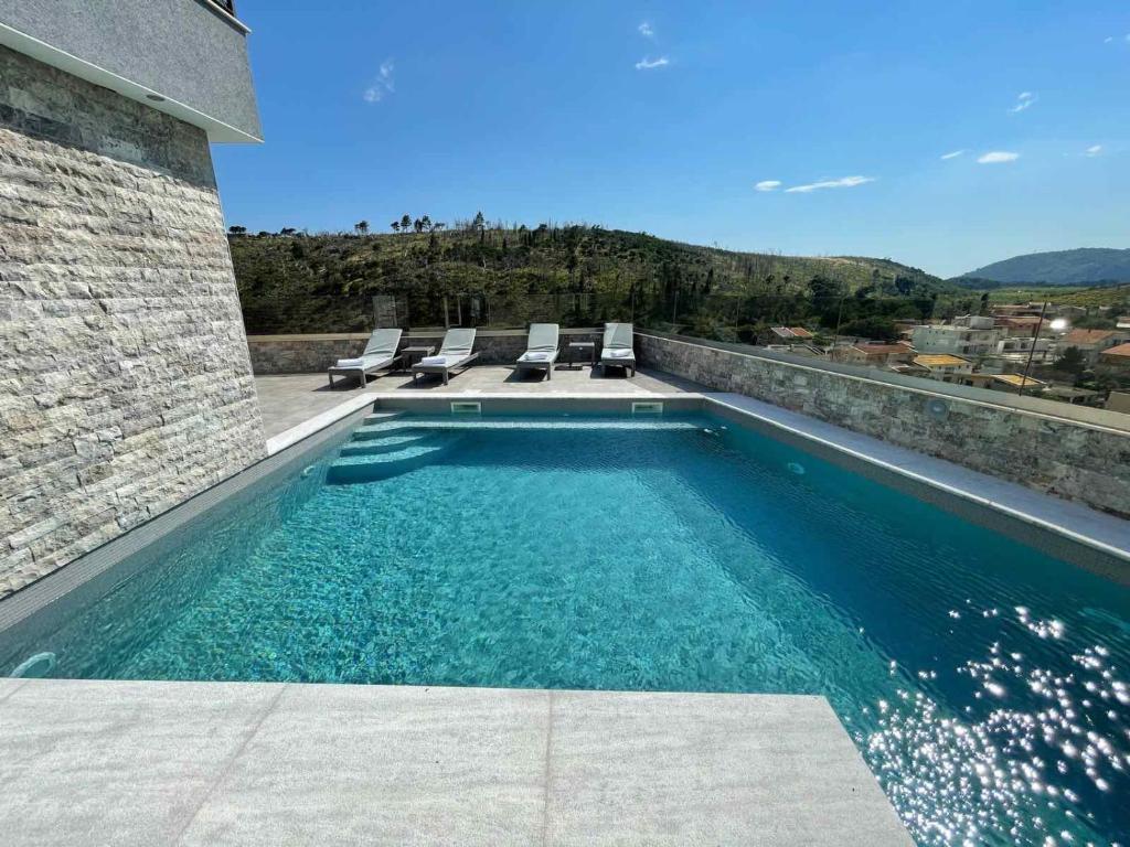 a swimming pool with lounge chairs on a house at Lamadu Residence in Sutomore