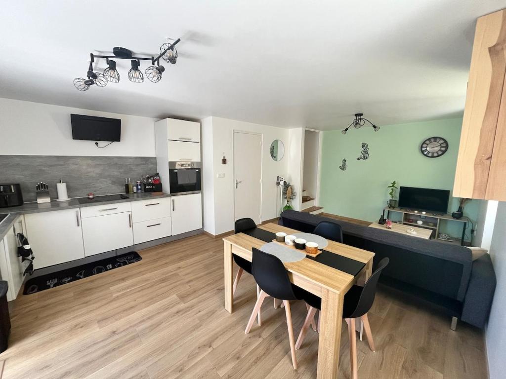 a living room with a dining table and a kitchen at Maison de village in Collanges