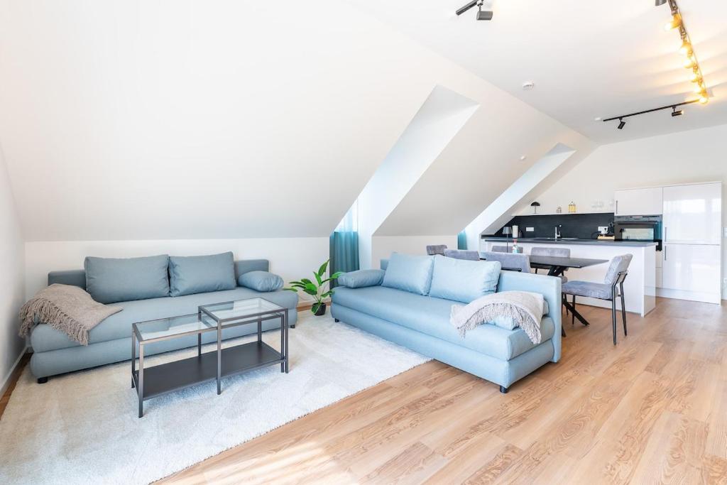 a living room with a blue couch and a table at Tonirooms 3-Zimmer Buntspecht in Straubing