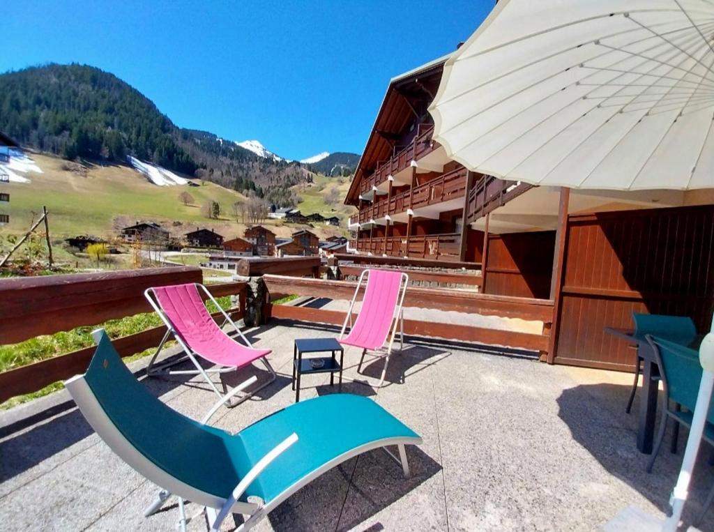 a group of chairs and an umbrella on a patio at Arêches, 4 pers, télésiège à 5 mn à pied, grande terrasse en RDJ in Beaufort