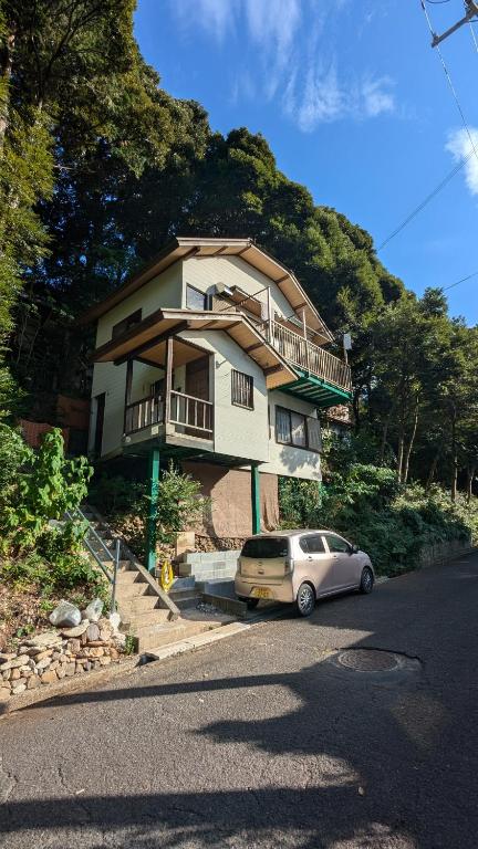 a house with a car parked in front of it at 伊根の宿 汐風 Shiokaze in Nomuro