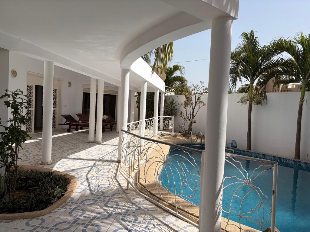 a house with a swimming pool next to a building at Luciana annexe in Mbour