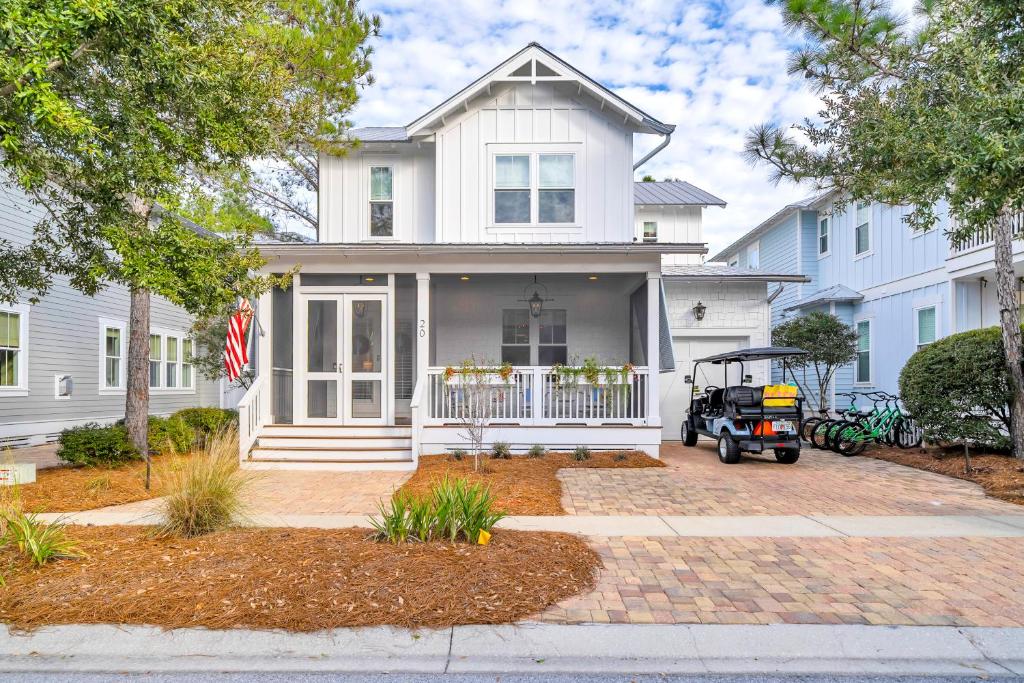 a white house with a golf cart in front of it at SeaPines on 30A in Santa Rosa Beach
