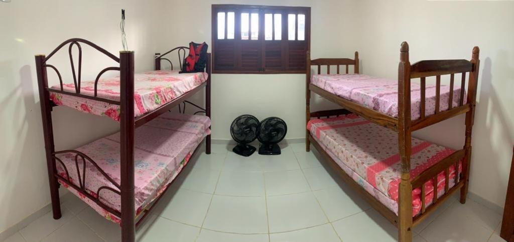 two bunk beds in a room with shoes on the floor at Casa em jacuma vip in Conde