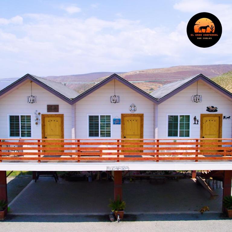 a white house with yellow doors on a bridge at Cabañas Privadas San Carlos Escape & Relax in Ensenada
