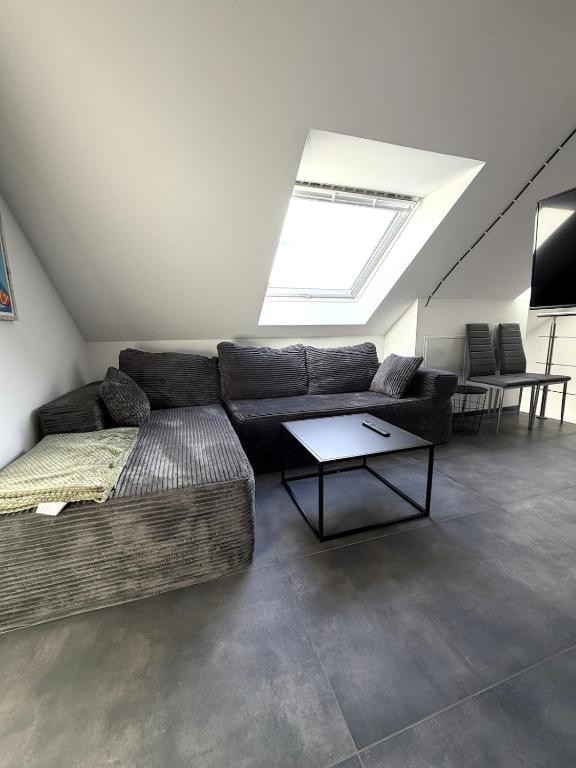 a living room with a couch and a skylight at Mira Suites 3 in Schwalbach