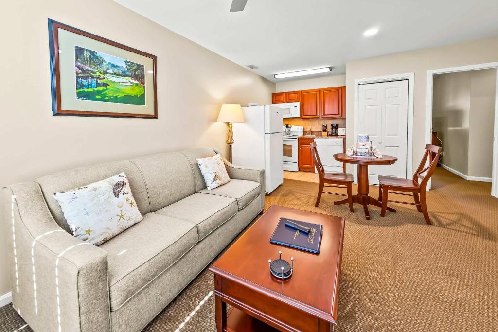 a living room with a couch and a table at Cozy 1st floor condo with golf course view in New Bern