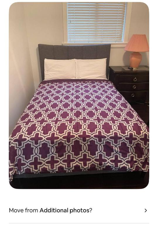 a bedroom with a bed with a purple and white comforter at Delta Guest House Merritt in Merritt