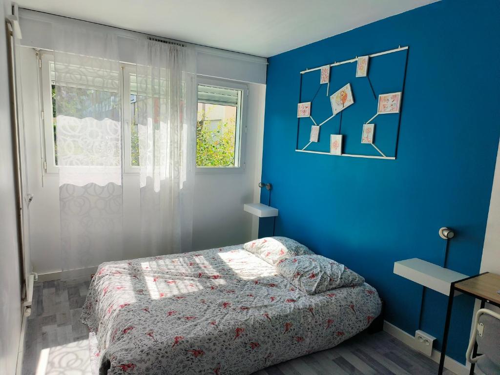 a blue bedroom with a bed and a window at Chambre spacieuse - appart sympa chez l'habitant in Saint-Herblain