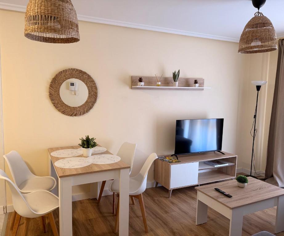 a living room with a table and a television at Apartamento Cueto II in Soto del Barco