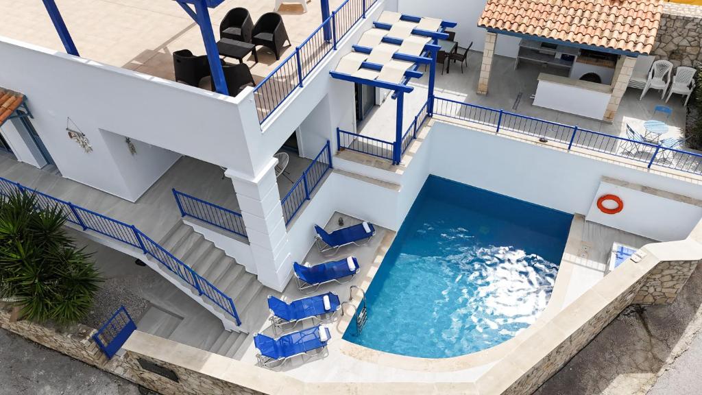an overhead view of a pool with blue chairs and stairs at Villa Salomon- Seafront Villa with Private Pool in Plaka