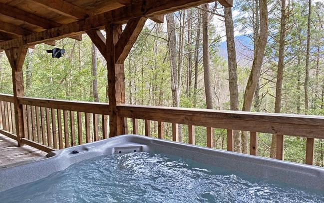 a hot tub on a porch with a wooden deck at Mountain Hideaway in Sevierville