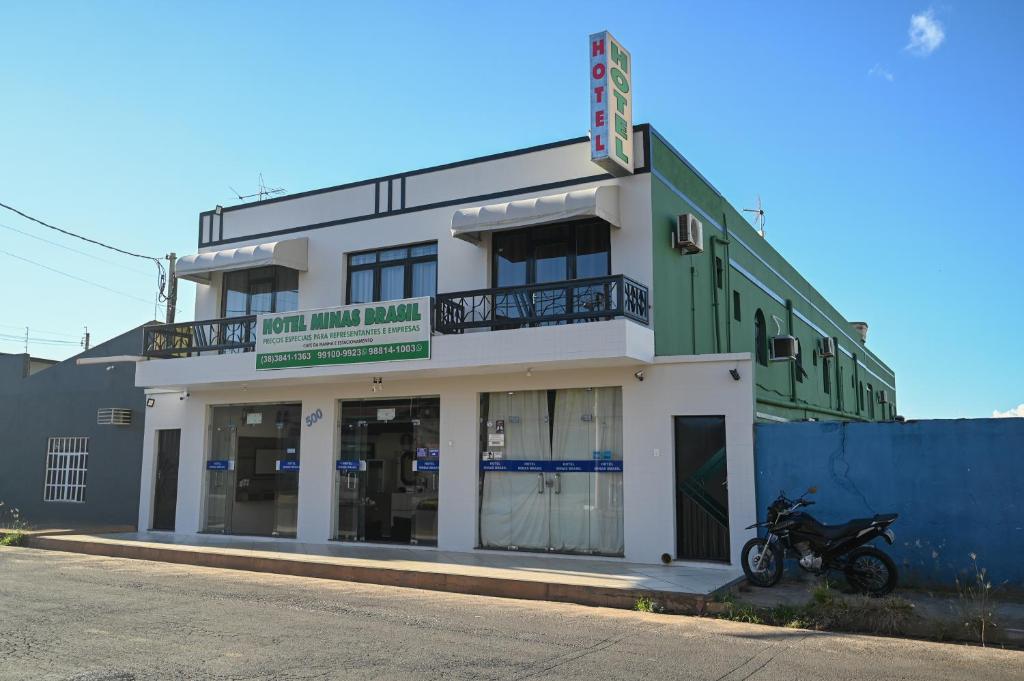 a building with a motorcycle parked in front of it at Hotel Minas Brasil in Salinas