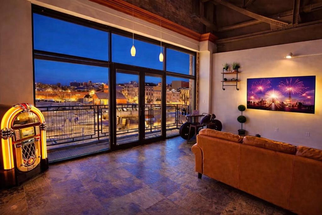 a living room with a couch and a large window at Mario Room Waterfront Downtown View Cedar Point! in Sandusky